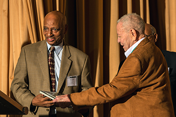 Merrick School of Business Professor, Tigi Mersha receives an award during the 25th Anniversary of POMS event, from Columbia University Professor Emeritus Marty Starr